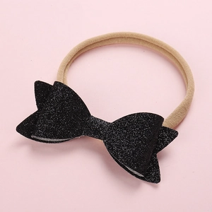 Detail view of a black sequin bow attached to a soft, stretchy nylon baby headband