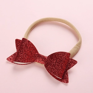 Close-up of red sequin bow on a soft nude nylon headband for infants and kids