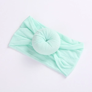 Soft mint green nylon baby headband with a donut knot design for infants