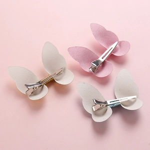 Detailed macro view of 3-piece fabric butterfly hair clips with glitter accents