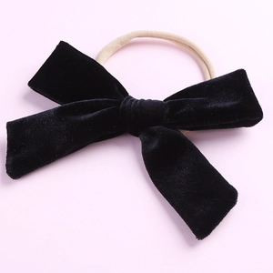 Détail d'un bandeau à nœud en velours noir pour filles avec bande en nylon souple