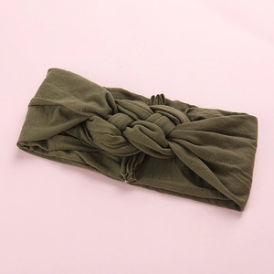 Détail du bandeau tricoté vert olive pour bébé avec design souple à nœud torsadé