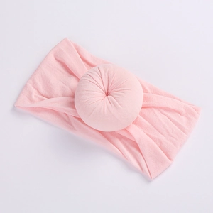 Soft light pink nylon baby headband featuring a flexible donut knot design