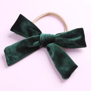 Vue détaillée d'un grand bandeau à nœud en velours vert foncé avec bande en nylon souple