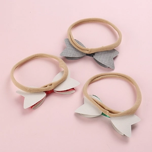 Detailed set of three sequin bow nylon headbands for babies in grey, red, and green
