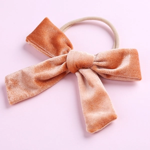 Détail du nœud en velours corail doux sur un bandeau extensible en nylon pour bébé