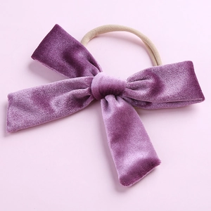 Vue détaillée d'un nœud en velours violet de 5 pouces sur un bandeau en nylon pour bébés