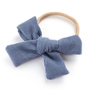 Bandeau bébé avec gros nœud en velours côtelé bleu et ruban en nylon élastique nude