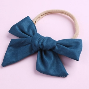 Gros plan sur le nœud en coton bleu marine et le bandeau élastique doux pour bébé
