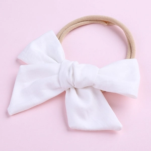 Détail du nœud en coton blanc et du bandeau en nylon extensible pour bébés