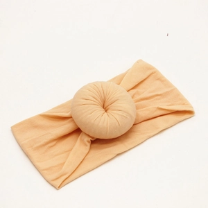 Soft nude pink nylon baby headband with stretchy donut knot design for infants