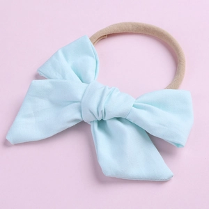 Détail d'un bandeau bébé avec nœud en coton bleu clair et bande élastique en nylon
