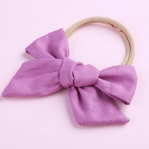 Détail d'un bandeau à nœud en coton violet pour bébé fille avec bande en nylon extensible