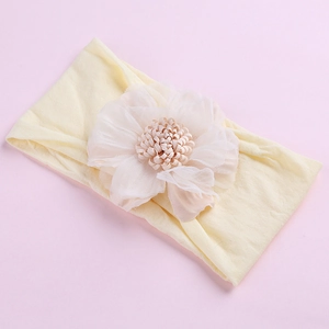 Macro detail of elastic nylon baby headband with delicate chiffon flower decoration