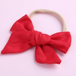 Détail du bandeau pour bébé avec nœud en coton rouge et bande en nylon extensible