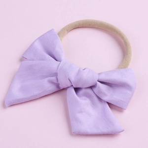 Détail d'un nœud en coton violet clair sur un bandeau en nylon élastique pour bébés