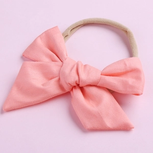 Détail du nœud rose en coton montrant la texture tissée et le bandeau élastique en nylon