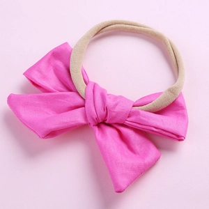 Détail du nœud en coton rose sur un bandeau élastique souple pour bébé fille