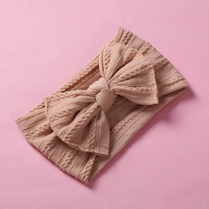Pink cable knit baby headband featuring a large bow for infants and toddlers