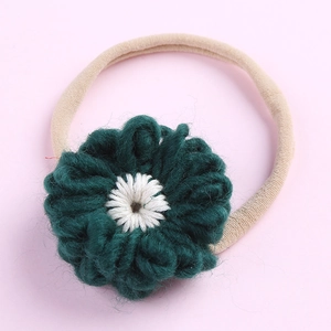 Gros plan du bandeau en nylon souple avec une grande fleur au crochet vert foncé