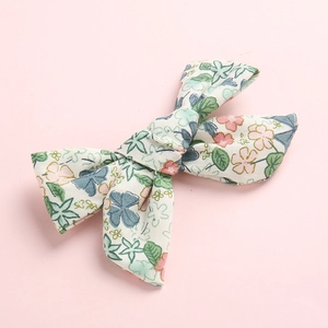 Katoenen strik haarclip met bloemenprint voor baby's op een roze achtergrond
