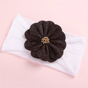Detailed macro view of soft nylon baby headband with large pleated fabric flower and gold beads