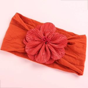 Elastic red nylon baby headband with a large handmade satin flower and pearl center