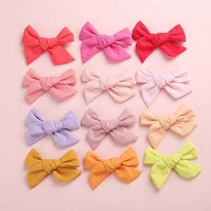Lot de 12 barrettes à nœud en coton et lin pour bébés filles disposées en grille 3x4