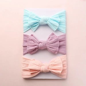 Three-pack of ribbed knit baby headbands with bow design in blue, purple, and pink colors