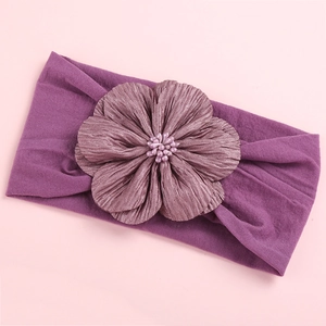 Macro shot of dark purple satin flower headband with detailed beads for infants