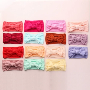 Close-up of 15-color nylon knit baby headbands set featuring large matching bows