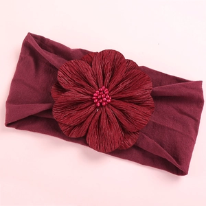 Detail of burgundy satin flower headband with beads on wide elastic nylon fabric
