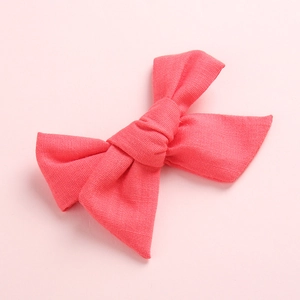 Gros plan sur le nœud papillon en lin rose corail avec texture de tissu pour filles