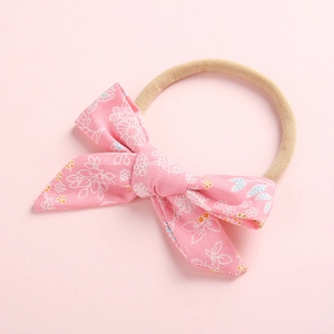 Close-up of baby floral bow headband with soft nude nylon elastic band for infants