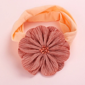 Detailed close-up of soft nylon baby headband featuring a pleated satin flower with beads