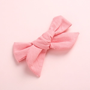 Détail d'un nœud papillon en coton rose montrant la texture côtelée de qualité