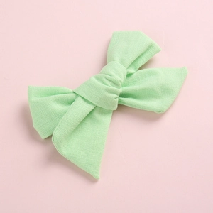 Vue détaillée du nœud papillon en lin vert clair avec texture tissée pour fillettes