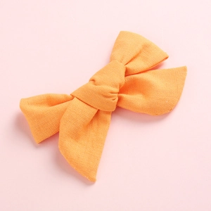 Barrette nœud papillon en lin et coton orange vif pour filles avec texture tissée naturelle
