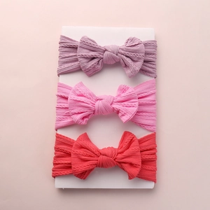 Three-pack set of soft nylon jacquard baby headbands with large bows in purple and pink