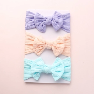 Detailed texture of jacquard nylon baby headbands with large bows in three pastel colors