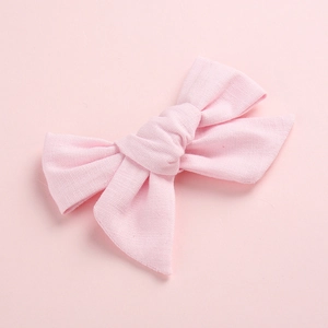 Détail du nœud rose pour bébé en lin montrant la texture du tissu et le nœud artisanal