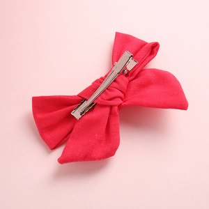 Vue détaillée du nœud rouge en coton avec pince crocodile en métal pour petite fille