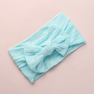 Detailed macro view of soft light blue jacquard nylon baby headband with a large bow