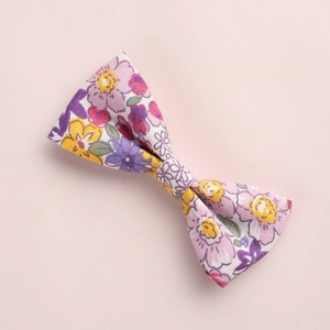 Gros plan détaillé d'un nœud papillon en coton floral avec des motifs violets et jaunes