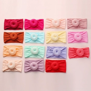 Detail showing high-elasticity ribbed knit baby headbands with doughnut knot in multiple colors