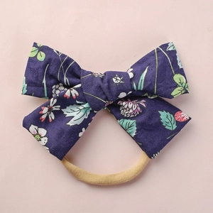 Detail eines Baby Stirnbands mit Erdbeer und Blumenmuster auf weichem Baumwollstoff