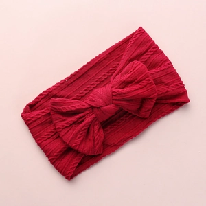 Macro detail of wine red cable knit baby headband with a soft oversized bow design