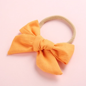 Gros plan détaillé du nœud en tissu orange et du bandeau élastique en nylon beige