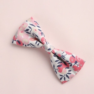 Vue détaillée de la pince à cheveux avec nœud en coton imprimé floral rose et feuilles bleues