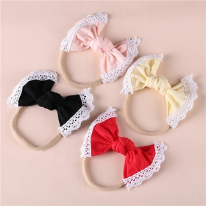 Detail of four baby headbands with lace edges and soft nylon bands in four colors
